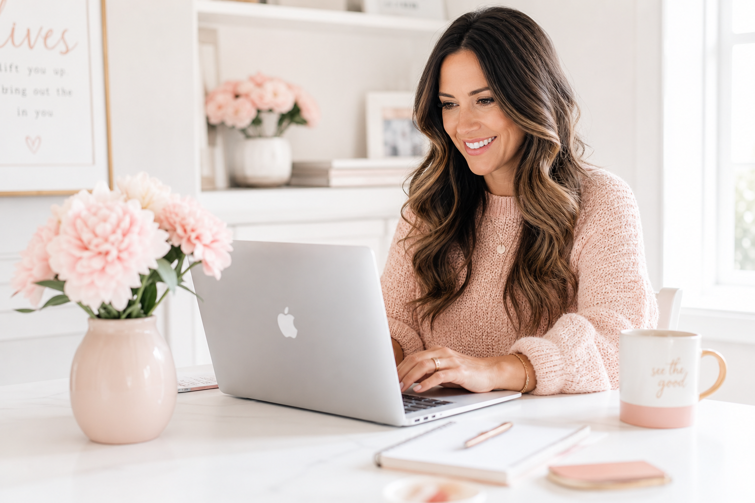 Friendly bookkeeper smiling while replying to a message at a bright, flower-filled desk